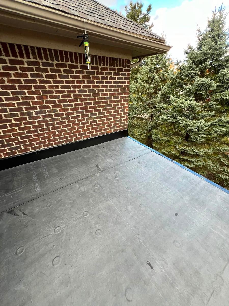 A finished membrane flat roof between brick walls